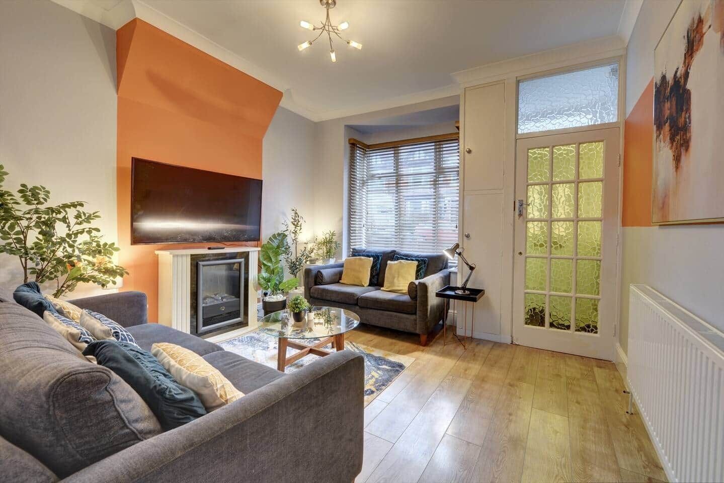 A living room with a fireplace, two sofas, a coffee table, and a TV.