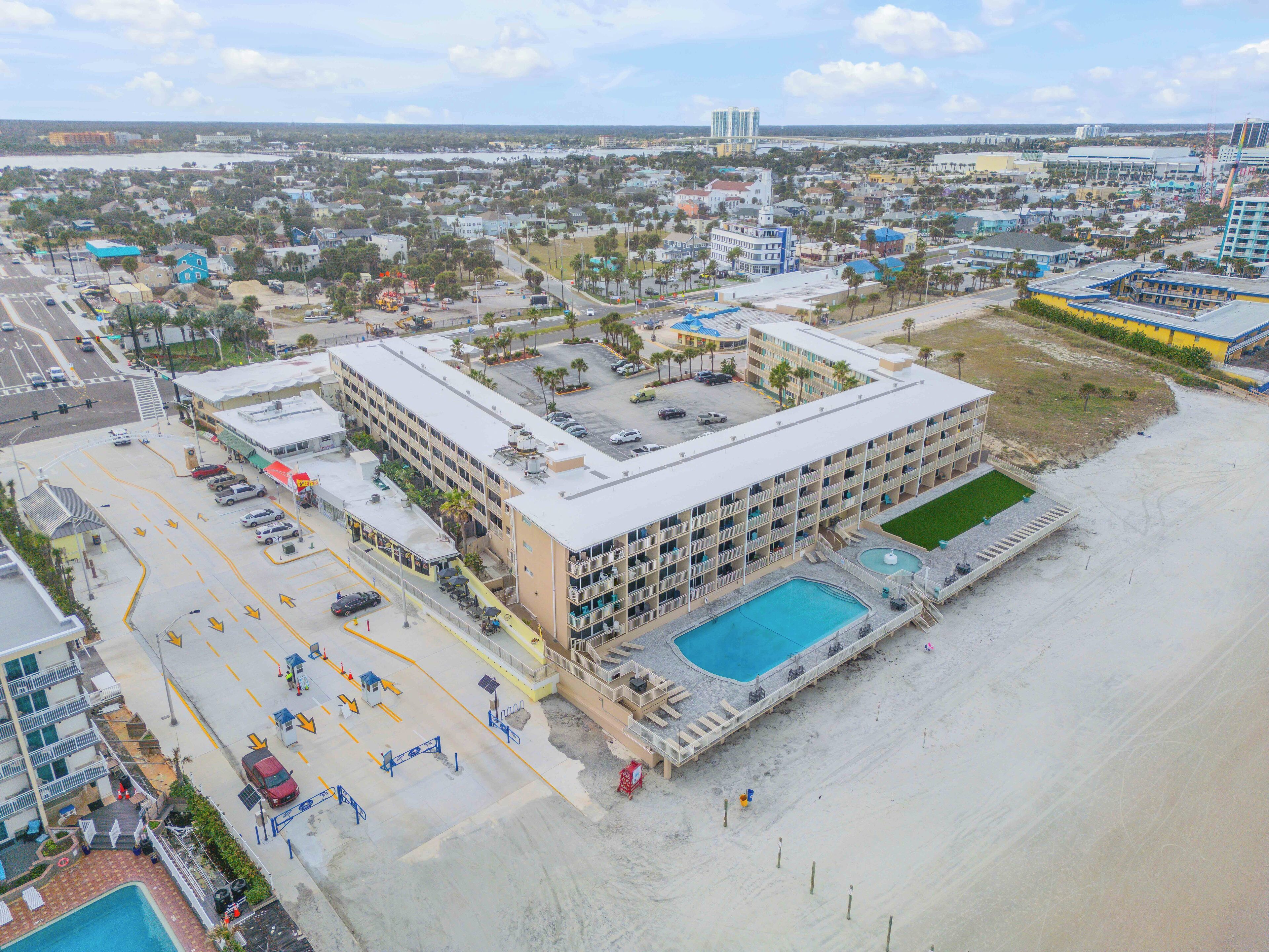 Ein Hotel mit Pool, mehreren Etagen und Blick auf den Strand.