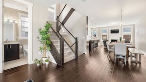 A modern interior with a staircase, a dining area, and a kitchen.