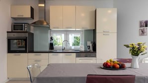 A modern kitchen with a central island, a built-in oven, a microwave, and a coffee maker. - House Lavanda a relaxing retreat with court & sauna (Marići)