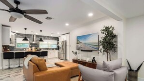 Une cuisine moderne avec un coin repas, un ventilateur de plafond et une grande fenêtre.
