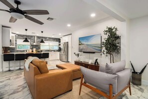 Eine moderne Küche mit Essbereich, Deckenventilator und großem Fenster.
