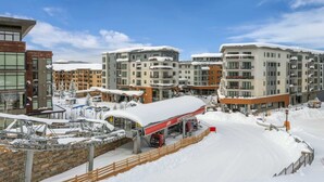 Ett snötäckt område i staden med moderna byggnader, en skidlift och en bensinstation.