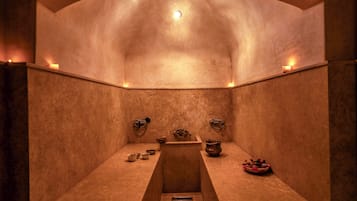 A spa room with a curved ceiling, a central bench, and a small altar with ritual items.