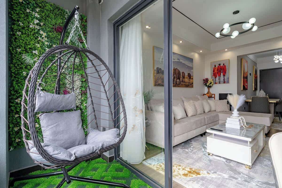 Una sala moderna con un sillón colgante, un sofá y una mesa de centro.
