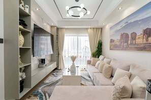 Ein modernes Wohnzimmer mit einer Couch, einem Fernseher und dekorativen Gegenständen.