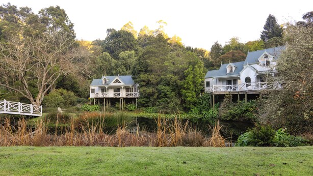 A house with a balcony and a wooden deck, surrounded by trees and a grassy area. - Plum Retreat - Apollo Bay (Apollo Bay)