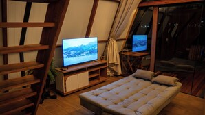 A cozy room with a bed, two TVs, wooden furniture, and a large window. - Mont Hermon Hotel Castro (Castro)