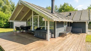 A covered deck with outdoor seating and a chimney. - Amazing home in Rørvig with sauna (Rørvig)