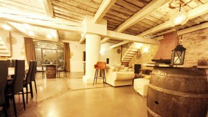 Un intérieur spacieux avec un plafond haut, un coin repas avec des chaises et une table, un canapé et un tonneau en bois.