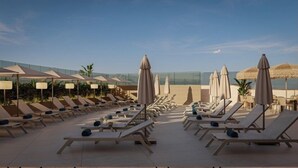 A rooftop pool area with sun loungers, umbrellas, and a clear view of the ocean. - Gran Hotel Luna de Cádiz *NEW* (Cádiz)