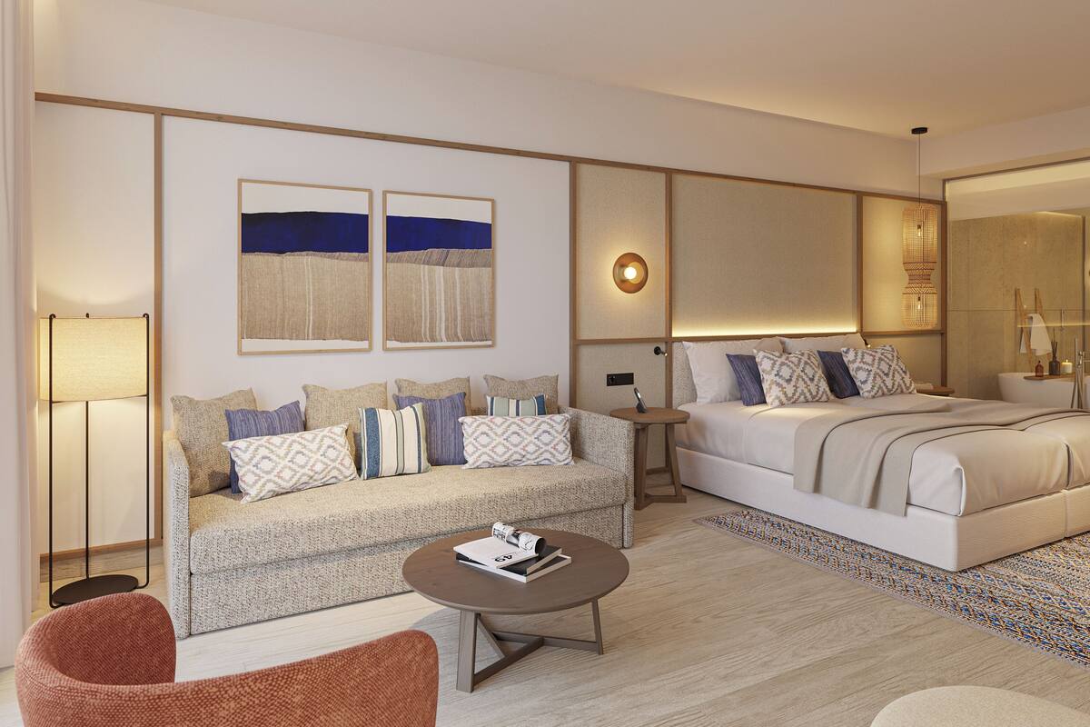 Une chambre d’hôtel moderne équipée d’un canapé, d’un lit, d’une table basse et d’une petite table avec une lampe.