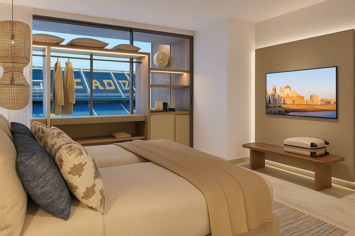 Une chambre d’hôtel moderne avec un grand lit, une télévision, un banc en bois et une vue sur le paysage urbain par la fenêtre.