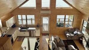 Ein großzügiges Loft mit Küche, Essbereich und Wohnzimmer, ausgestattet mit großen Fenstern und einer hohen Decke.