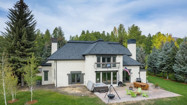 A two-story house with a patio, a swing set, and a flag. - Fairway Twelve Retreat (Sun Valley)