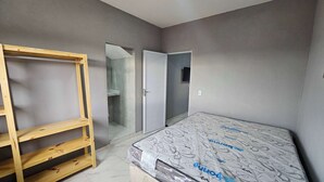 A room with a wooden wardrobe, a closed door, and a mattress on the floor. - Waterview Apartment w/Ocean Breezes Near Jeri (Preá - CE)