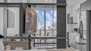 A modern hotel room with a city view, a bed, a desk, and a kitchen area. - Luxury Miami Studio with Rooftop Pool (Miami)