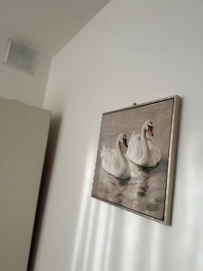 A painting of two swans on a wall. - Cosy double bedroom near Eurostar & KX (London)