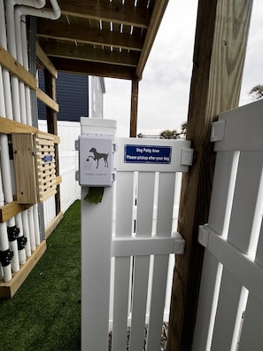 A dog potty area with a sign instructing to pick up after your dog and clean up. - Topsail Beach Sunsets, Water views, Pool/Hot tub (N. Topsail Beach)