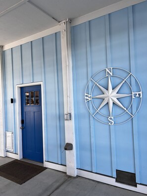 A blue door with a window, a white mailbox, and a compass on the wall. - Topsail Beach Sunsets, Water views, Pool/Hot tub (N. Topsail Beach)