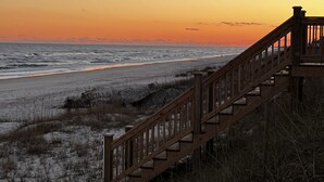 A wooden staircase leading down to a beach with a sunset in the background. - Topsail Beach Sunsets, Water views, Pool/Hot tub (N. Topsail Beach)