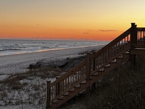 A wooden staircase leading down to a beach with a sunset in the background. - Topsail Beach Sunsets, Water views, Pool/Hot tub (N. Topsail Beach)