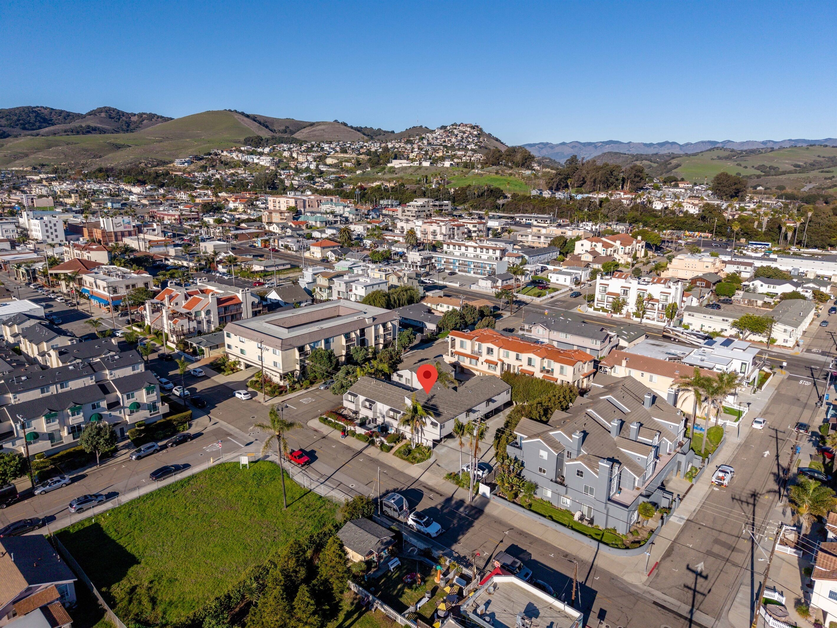 An aerial view of a residential area with houses, streets, and a large building with a flat roof.