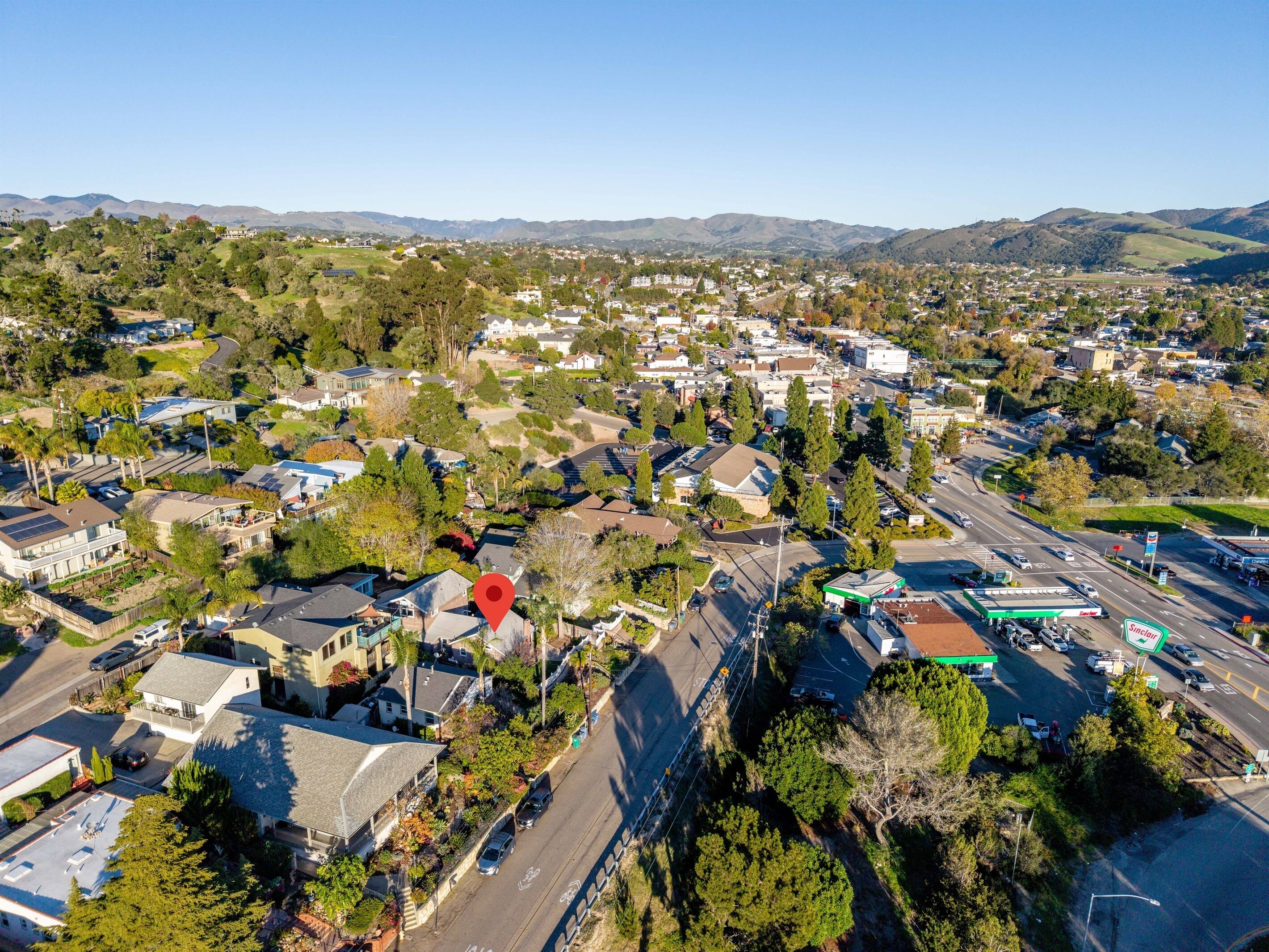 An aerial view of a residential area with houses, roads, and a gas station.