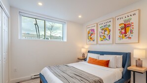 A bedroom with a bed, a window, and three Picasso paintings on the wall. - Chic City Hideaway | Vibrant Heart of Montréal (Montreal)