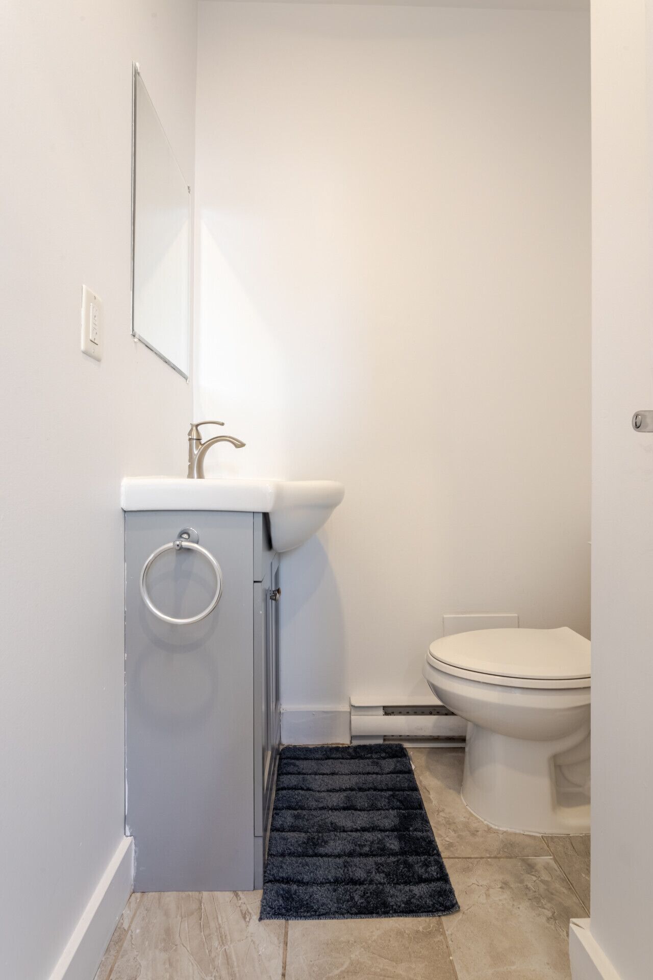 Une petite salle de bain avec des toilettes, un lavabo et un miroir.