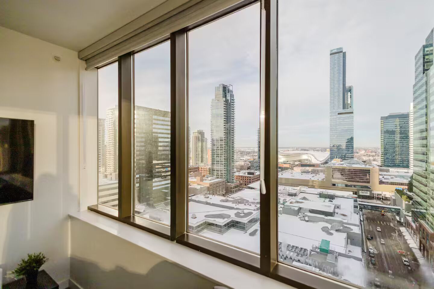 Un appartement situé dans un immeuble de grande hauteur, doté de grandes fenêtres offrant une vue sur la ville.