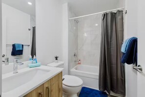 A modern bathroom with a white sink, a toilet, a shower, and a bathtub. - Upscale Lux Dt, King Bed, Views (Edmonton)