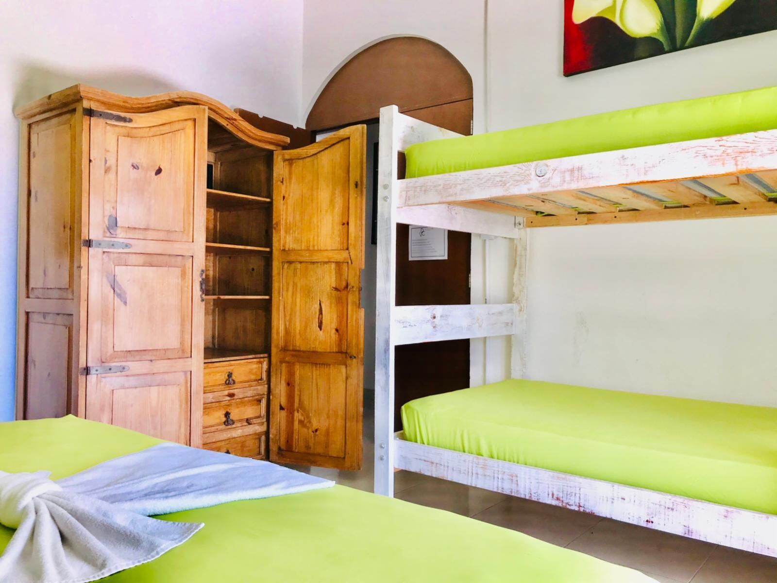 Ein Zimmer mit Etagenbetten, einem Holzschrank und einem Bild an der Wand.