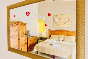 A hotel room with a wooden wardrobe, a bed with white bedding, a bedside table, and a wall-mounted artwork. - Dolce Vita Caribe Comfort Family Balcony Double Room Pool Self Check-in Playacar (Playa del Carmen)