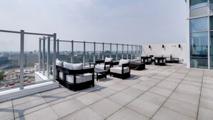 Eine Dachterrasse mit Sitzgelegenheiten und Blick auf die Stadt.