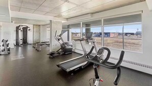 A gym with treadmills, elliptical machines, and weight equipment. - Luxury 2BR, 10ft ceiling, 5 mins from Dt (Edmonton)