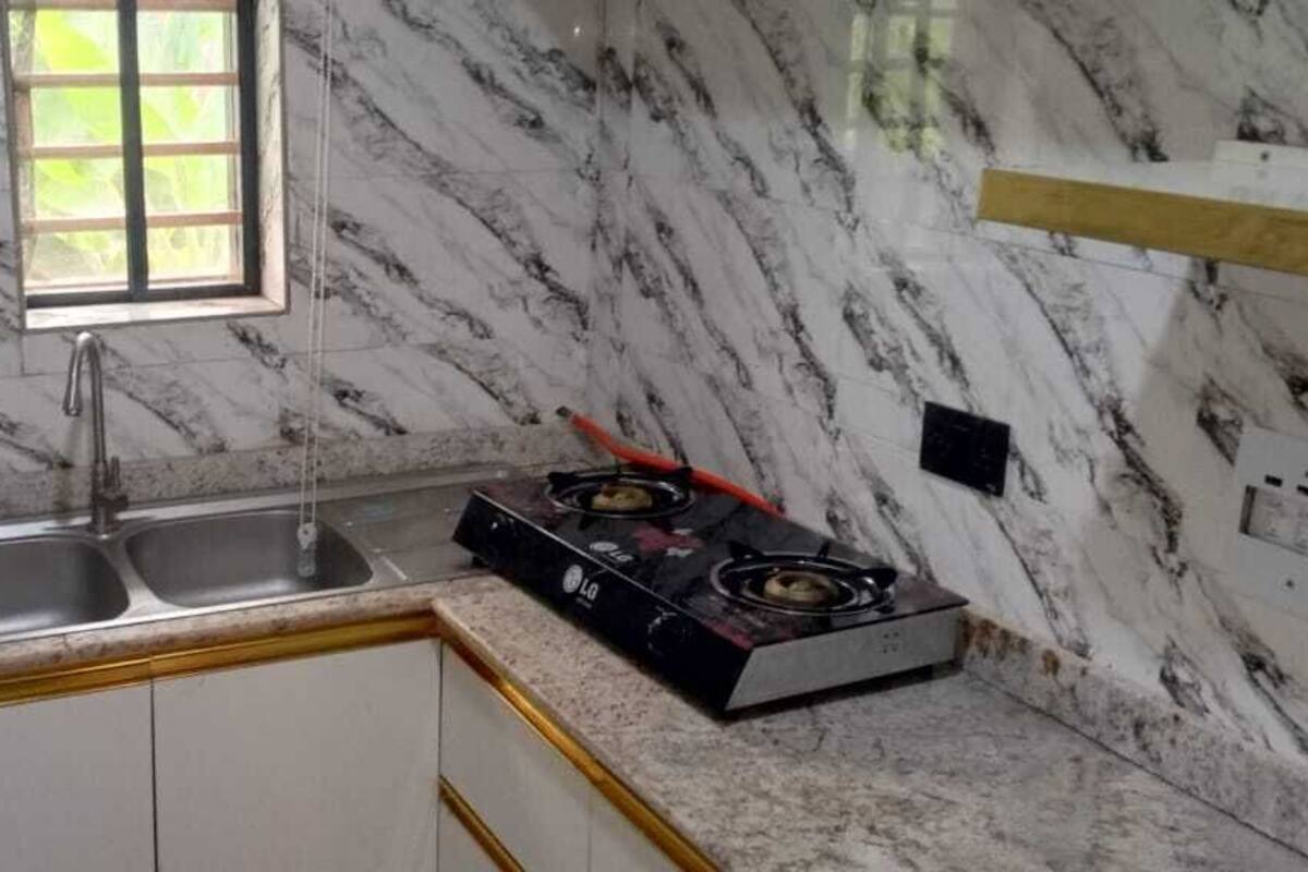 Una cocina con encimeras de mármol, un lavamanos doble y una estufa a gas.
