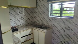 A small kitchen with a marble backsplash, a window, and a sink. - 517VIP Suites and Apartments Awka (Awka)
