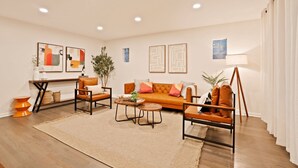 Una sala de estar moderna con un sofá, sillones, una mesa de centro y una lámpara de pie.