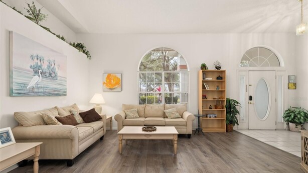 A living room with two beige sofas, a coffee table, and a bookshelf. - Cozy 4 Bedroom Home with South Facing Pool & 4 bedroom home (Davenport)