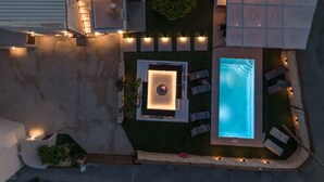 Ein Luftbild eines Daches mit einem Swimmingpool, Sitzgelegenheiten im Freien und einer Feuerstelle.