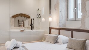 Ein Hotelzimmer mit Bett, Badewanne, Handtuchhalter und Fenster.