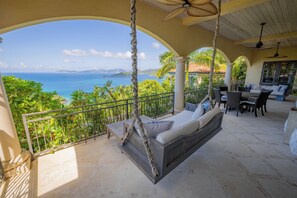 Un balcon doté d’un hamac suspendu, d’un espace repas extérieur et offrant une vue sur l’océan.
