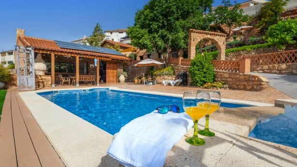 A pool area with a white towel and two glasses of orange juice on the edge. - Almoguer Rural Complex (Frailes)