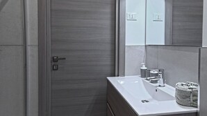 A modern bathroom with a wooden door, a white sink, and a mirror with integrated lighting. - Paint Venice House (Venezia)