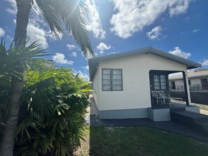 A small, single-story building with a flat roof, a front door, and a window. - Cozy 2-bedroom house in tranquil West Terrace with AC (West Terrace)