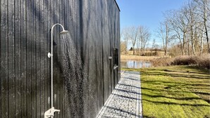 Ein modernes Gebäude mit großem Fenster, Metallkonstruktion und befestigter Fläche.