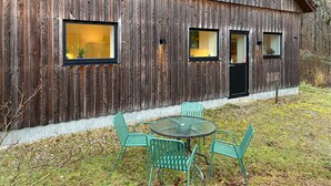 Maalaishenkinen puurakennus, jossa on kolme ikkunaa ja ovi.