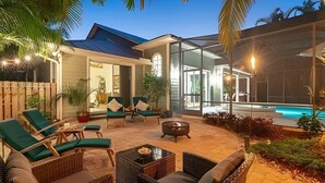 Eine moderne Außenpatio mit Liegestühlen, einer Feuerstelle und einem Poolbereich.