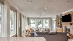 A spacious living room with a fireplace, a television, and a large window. - Stunning Views, Open Water, Hot Tub, 5 BR, 4 BA (Granbury)